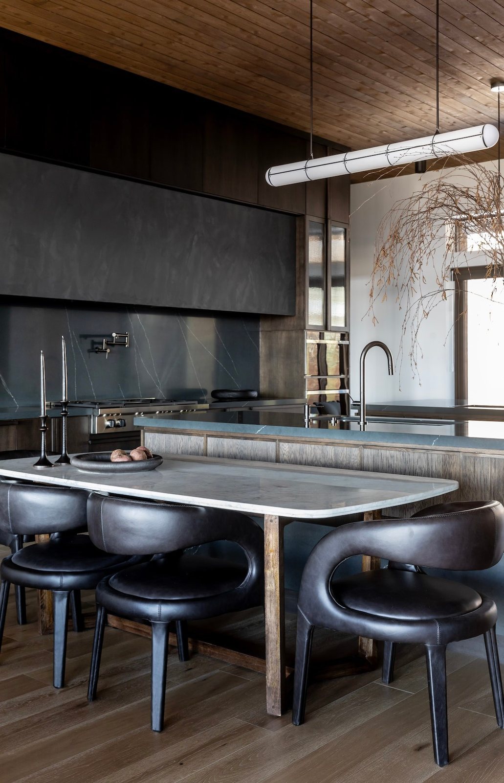 Dark kitchen with marble island and leather stools