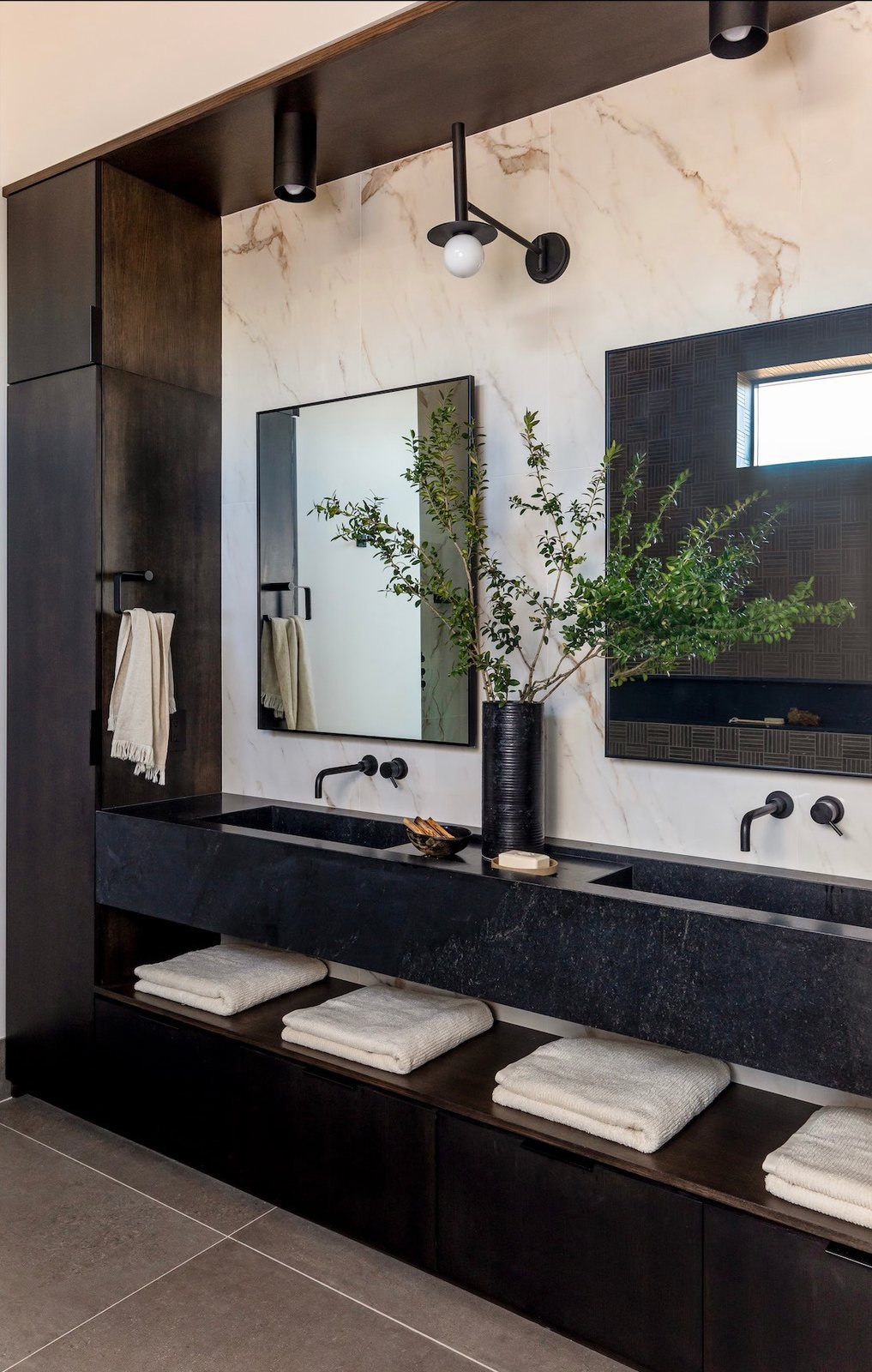 Bathroom with dark vanity and marble wall