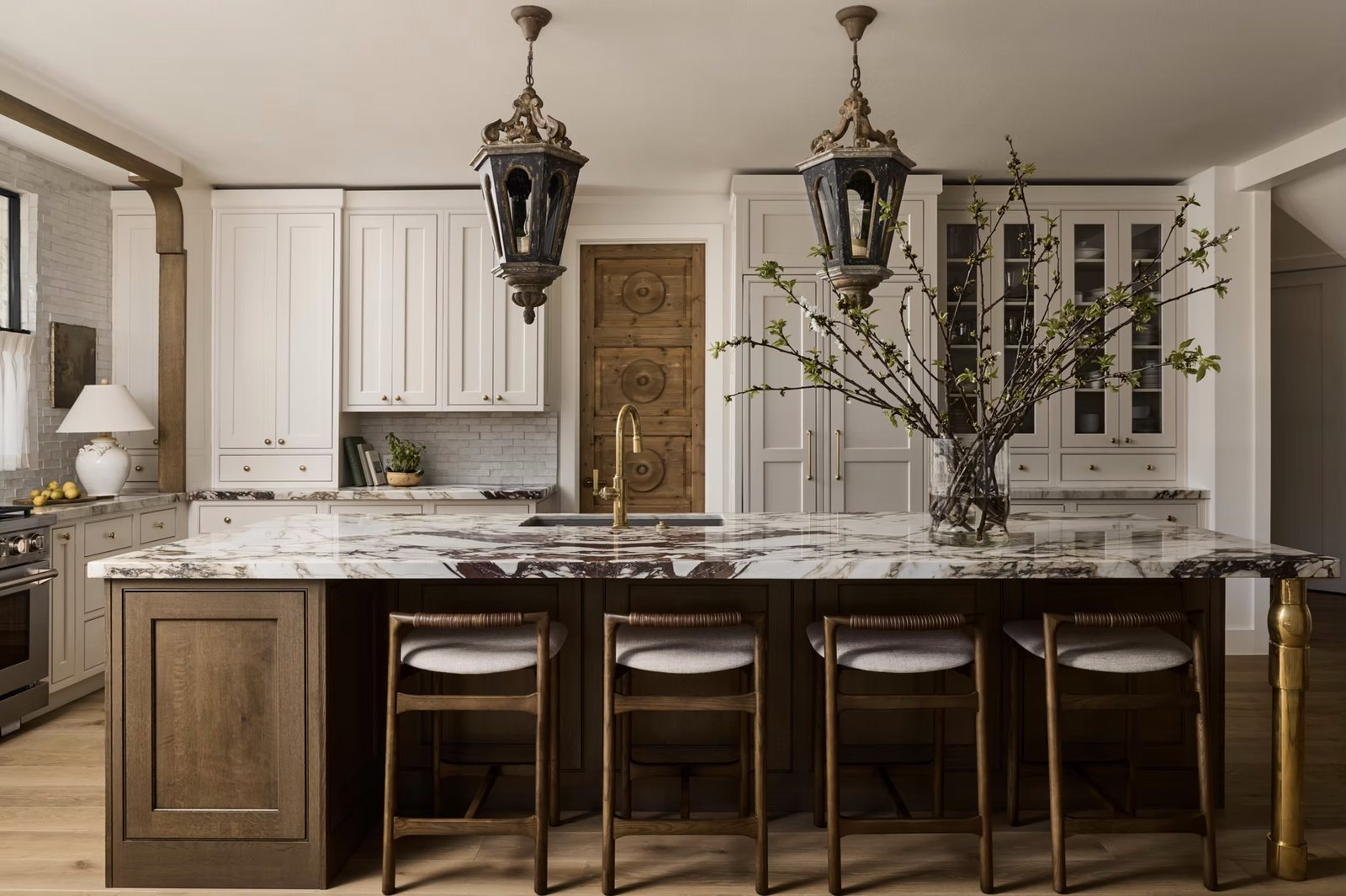 Eagle kitchen: oak island with veined marble, antique lanterns and white inset cabinetry
