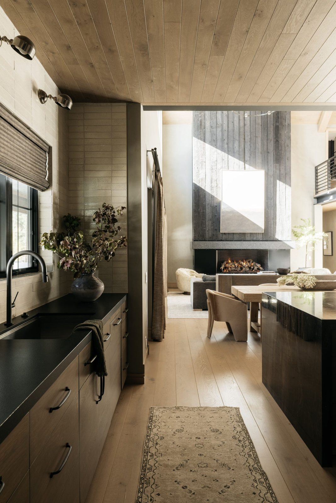 View from the kitchen to a board-formed fireplace in the great room