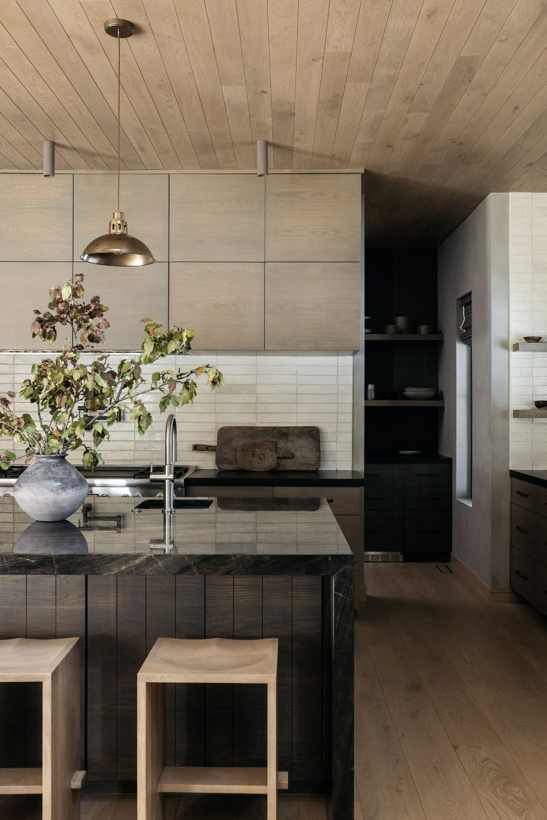 Kitchen with flat-panel oak uppers, handmade white tile and a dark stone island