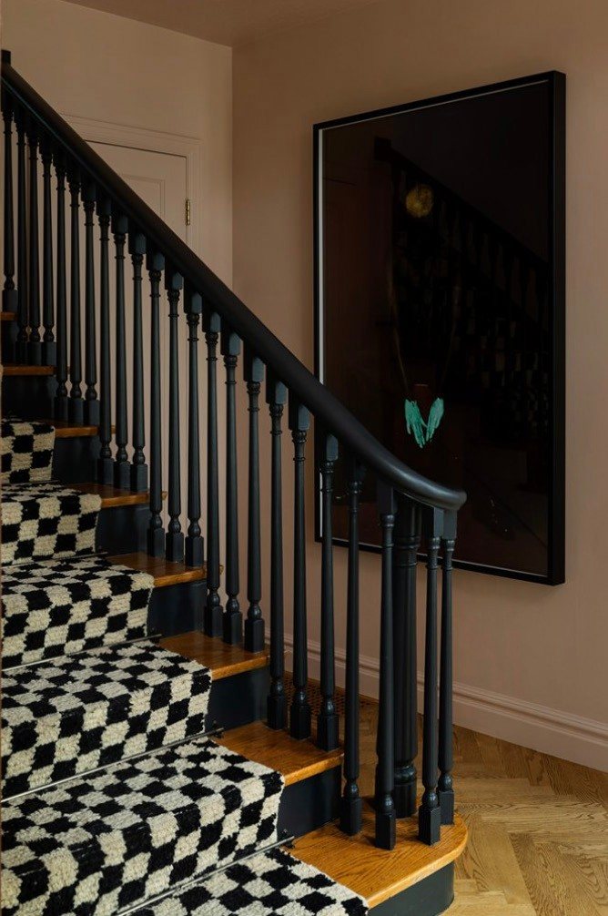 Staircase with checkered runner and black spindles